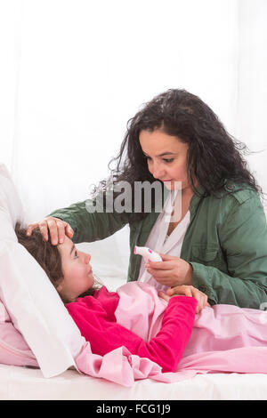 mother taking care of her sick daughter Stock Photo
