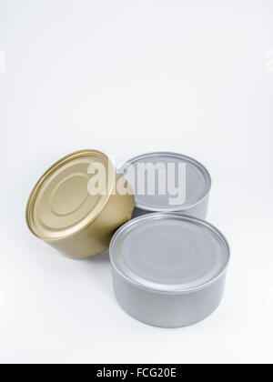 Two silver and one gold can of tuna with no label agaisnt a white background. Stock Photo