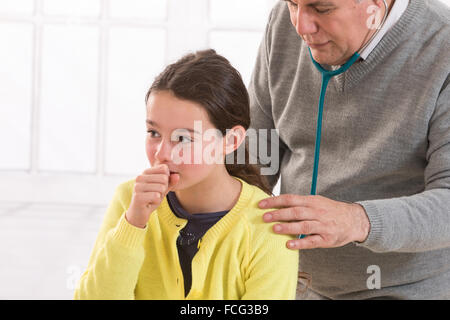 close up of teen  girl and doctor hand with stethoscope listening to heartbeat Stock Photo