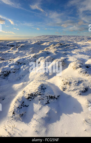 Snowy moorland beside the Pennine way above Glossop in Derbyshire on a breathtaking winter evening at sunset. Stock Photo