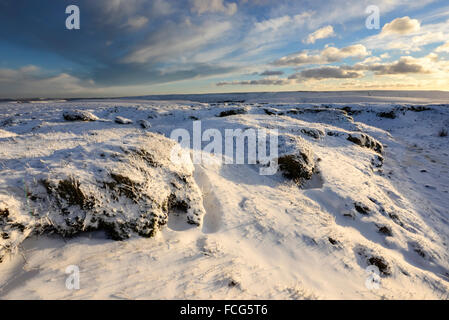 Snowy moorland beside the Pennine way above Glossop in Derbyshire on a breathtaking winter evening at sunset. Stock Photo