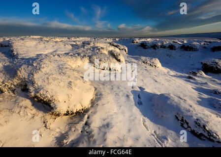 Snowy moorland beside the Pennine way above Glossop in Derbyshire on a breathtaking winter evening at sunset. Stock Photo