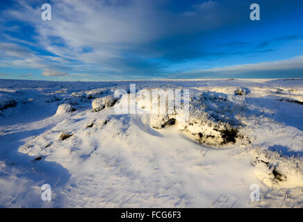 Snowy moorland beside the Pennine way above Glossop in Derbyshire on a breathtaking winter evening at sunset. Stock Photo