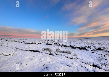 Snowy moorland beside the Pennine way above Glossop in Derbyshire on a breathtaking winter evening at sunset. Stock Photo