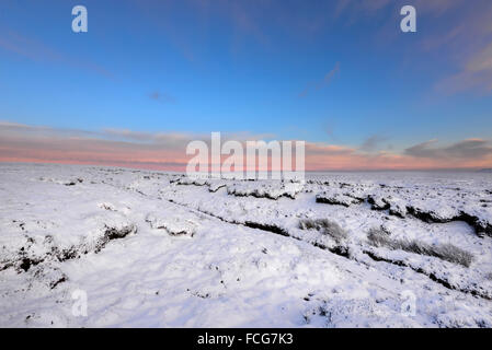 Snowy moorland beside the Pennine way above Glossop in Derbyshire on a breathtaking winter evening at sunset. Stock Photo