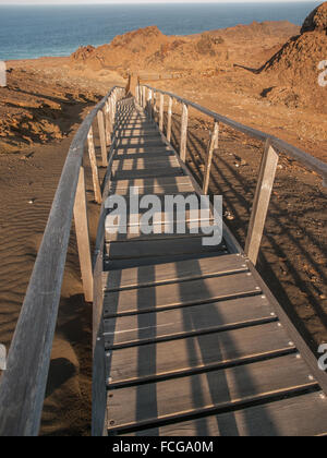 Wooden plank boardwalk with railing climbing uphill to a viewing platform on Bartolome, Galapagos Islands, Ecuador. Stock Photo