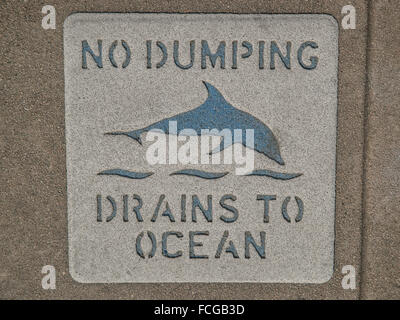 Sign on sidewalk that says No Dumping Drains to Ocean with a picture of a dolphin in Los Angeles California. Stock Photo