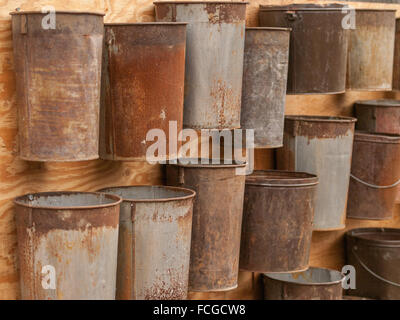 Collection of rusted vintage maple tree sap collecting buckets pinned up on a wooden board in Clarkson, Mississauga, Ontario, Ca Stock Photo