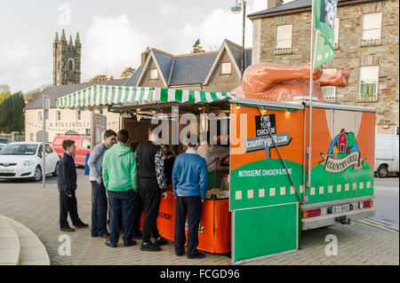 Group of boys queue at a mobile catering van, selling chicken products, at the Friday market in The Square, Bantry, Ireland. Stock Photo