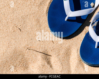 a pair of flip-flops left on the sand Stock Photo