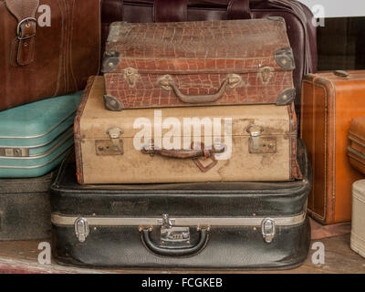 Stack of old dirty vintage suitcases in a Thrift Store window. Stock Photo