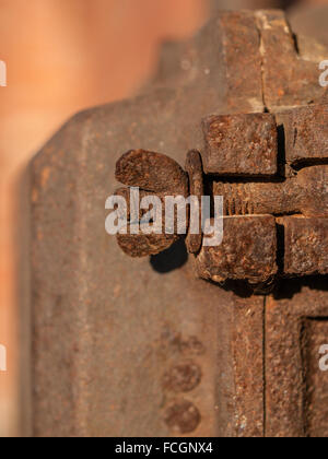 Rusty wing nut and bolt fastened in wall. Stock Photo