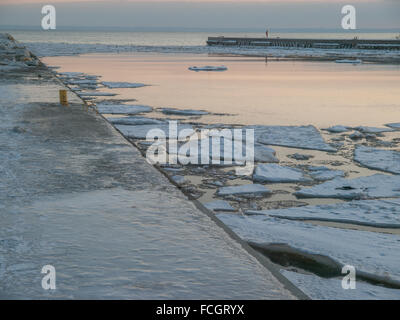 Ice covered pier and Lake Ontario at sunset in winter in Oakville, Ontario, Canada. Stock Photo