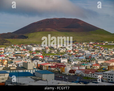 Eldfell volcano in front of cityscape in Heimaey, Vestmannaeyjar, Iceland. Stock Photo