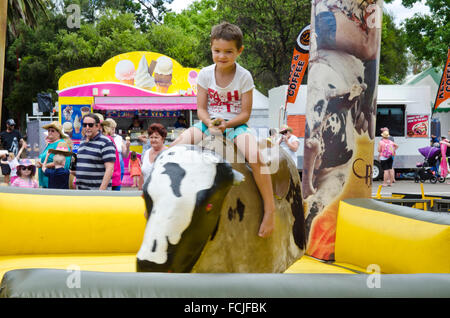 Young boy riding a mechanical bull Stock Photo