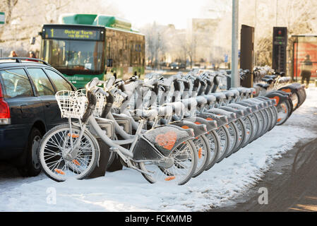 Lund, Sweden - January 21, 2016: Rental bikes parked in winter urban landscape. Lundahoj has renting stations like this all over Stock Photo
