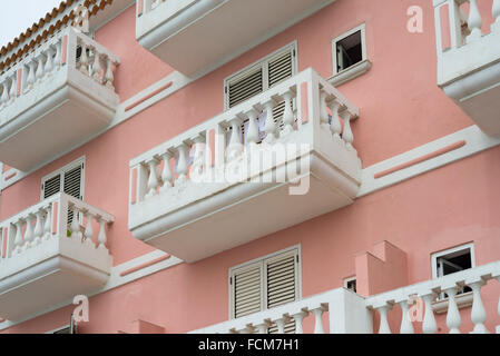 White balconies and blinds on a salmon-coloured facade of a mediterranean house in the Cilento region in southern Italy Stock Photo