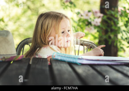 Beautiful blond girl in the garden at sunny summer day Stock Photo