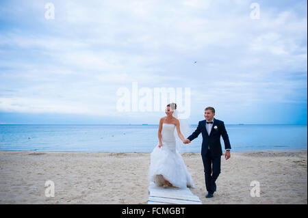 The newlyweds are walking on the beach. Stock Photo