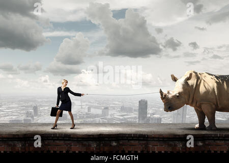 Young Pretty Businesswoman Holding Rhino On Lead Stock Photo - Alamy