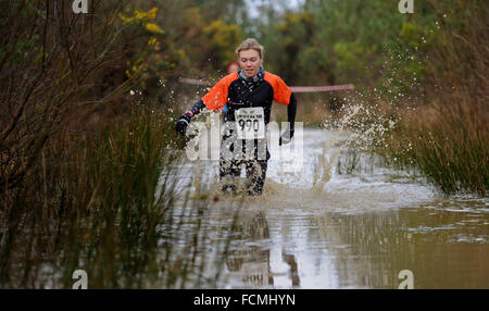 Aldershot, Hants, UK. 23rd January, 2016. Andrea Berquez  makes her way through the flooded streams of the Brutal women only  10km  race at Long valley Aldershot Hampshire having to break the ice as the make there way around the course .  The recent weather made the Brutal 10km off road course live up to its name as the puddles and streams where up to waste height in many places with early runners having to break the ice as they entered the water.  Credit:  PBWPIX/Alamy Live News Stock Photo