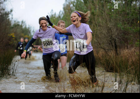 Aldershot, Hants, UK. 23rd January, 2016. Participants  makes there way through the flooded streams of the Brutal women only  10km  race at Long valley Aldershot Hampshire having to break the ice as the make there way around the course .  The recent weather made the Brutal 10km off road course live up to its name as the puddles and streams where up to waste height in many places with early runners having to break the ice as they entered the water.  Credit:  PBWPIX/Alamy Live News Stock Photo