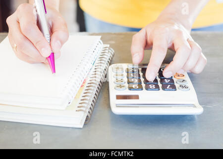 Hand holding pen and pressing calculator buttons, stock photo Stock Photo