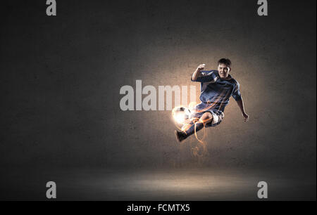 Football player in high jump taking ball Stock Photo