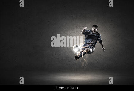 Football player in high jump taking ball Stock Photo