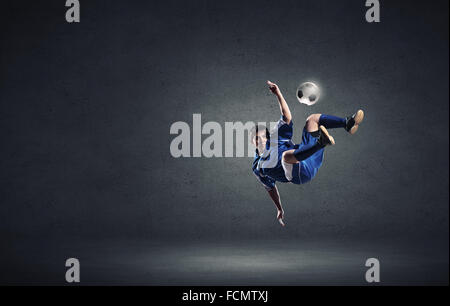 Football player in high jump taking ball Stock Photo