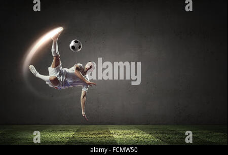 Football player in high jump taking ball Stock Photo