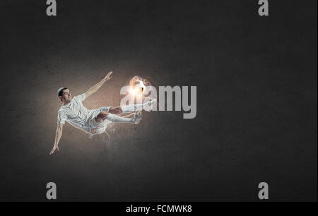 Football player in high jump taking ball Stock Photo