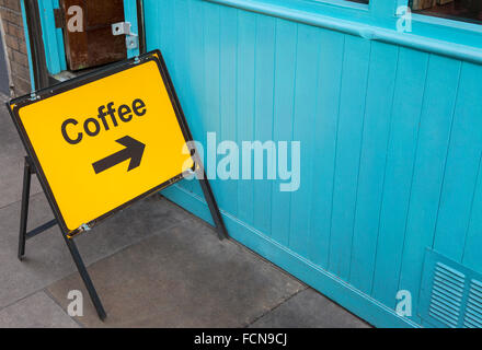 A sign displaying the direction for people who need a coffee. Stock Photo