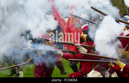 Black powder shoot in Nantwich, Cheshire, UK. Battle Flags fly at the Siege of Nantwich re-enactment.  For over 40 years the faithful troops of The Sealed Knot have gathered in the historic town for a spectacular re-enactment of the bloody battle that took place almost 400 years ago and marked the end of the long and painful siege of the town.  Roundheads, cavaliers, and other historic entertainers converged upon the town centre to re-enact the Battle. The siege in January 1644 was one of the key conflicts of the English Civil War. Stock Photo