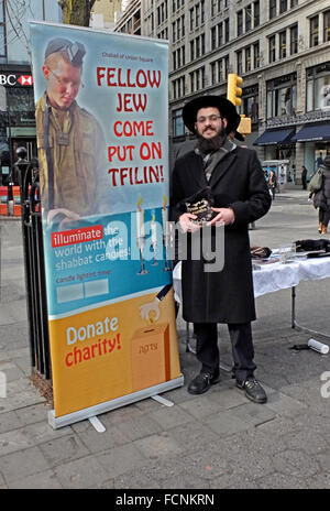 A religious Jewish man encourages other Jews to wear phylacteries - tefillin - in UNion Square Park in New York City. Stock Photo