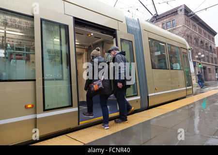 Seattle, USA. 23rd Jan, 2016. Couple entering the gold car at the Occidental Mall Station during the Settle Streetcar First Hill Line inaugural run - January 23, 2016. The First Hill Streetcar is a 4 kilometer-long line that connects Pioneer Square and Capitol Hill via the International District, Yesler Terrace, and First Hill. It is the second line implemented after the South Lake Union Streetcar opened in 2007. Credit:  Paul Gordon/Alamy Live News Stock Photo