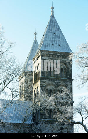 Lund, Sweden - January 21, 2016: The towers of Lund cathedral framed by frosty trees and blue sky. The church was founded in 108 Stock Photo