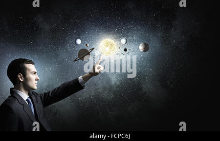 Young businessman and planets of space spinning around Stock Photo