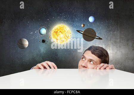 Young businessman and planets of space spinning around Stock Photo