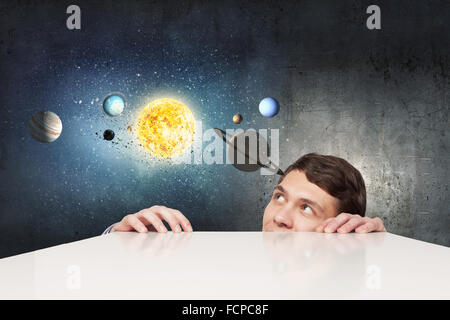 Young businessman and planets of space spinning around Stock Photo