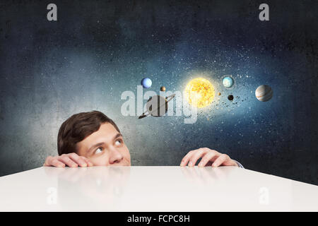 Young businessman and planets of space spinning around Stock Photo