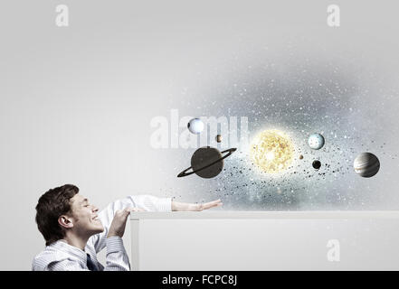 Young businessman and planets of space spinning around Stock Photo