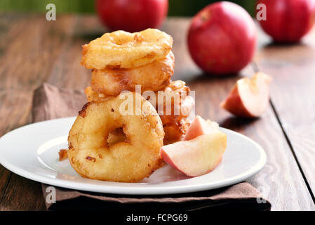 Apple rings on white plate on wooden background Stock Photo