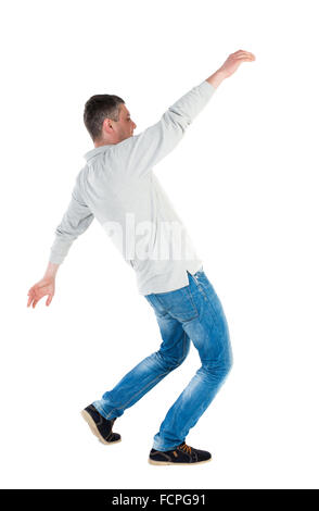 Back view man Balances waving his arms. Rear view people collection. backside view of person. Isolated over white background. A guy in a gray jacket waving his arms in the fall. Stock Photo