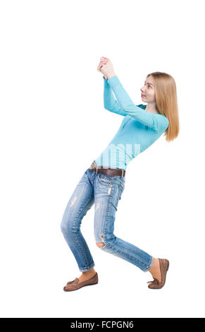 back view of standing girl pulling a rope from the top or cling to something. girl watching. Rear view people collection. backside view of person. Isolated over white background. Stock Photo