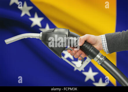 Fuel pump nozzle in hand with flag on background - Bosnia and Herzegovina Stock Photo