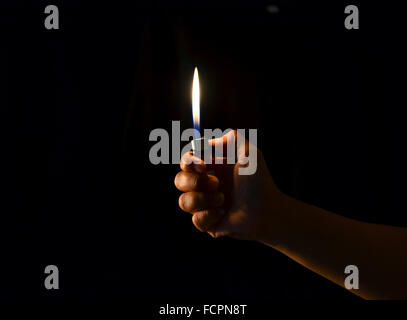hand hold a lighter in dark background Stock Photo