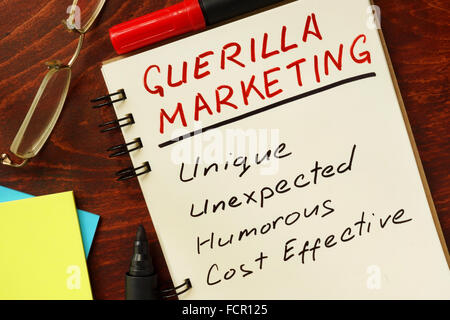 Notepad with guerilla marketing on the wooden table. Stock Photo