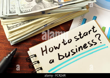 Notepad with how to start a business on the wooden table. Stock Photo