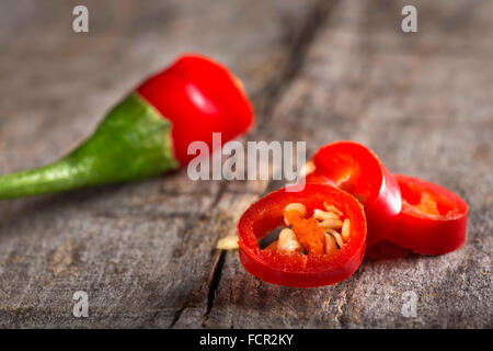 Red chili peppers slices over wooden background Stock Photo
